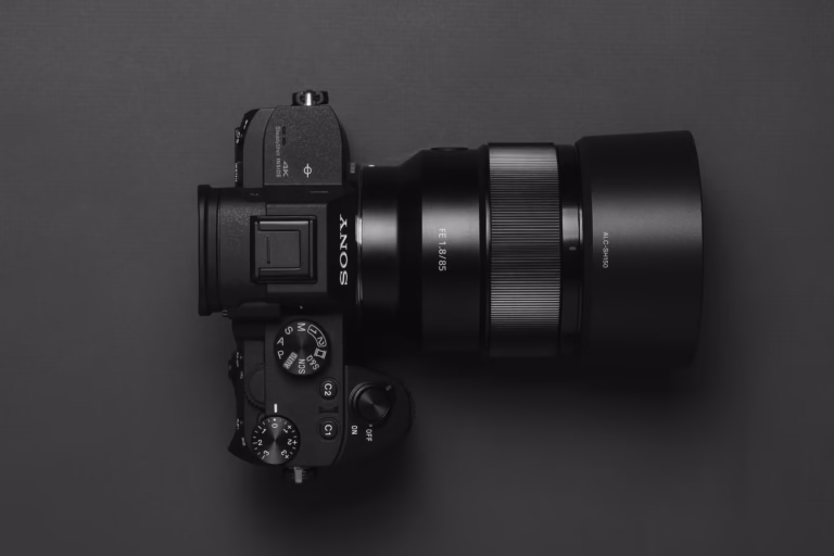 Top view of a sleek black DSLR camera with lens displayed on a dark background.